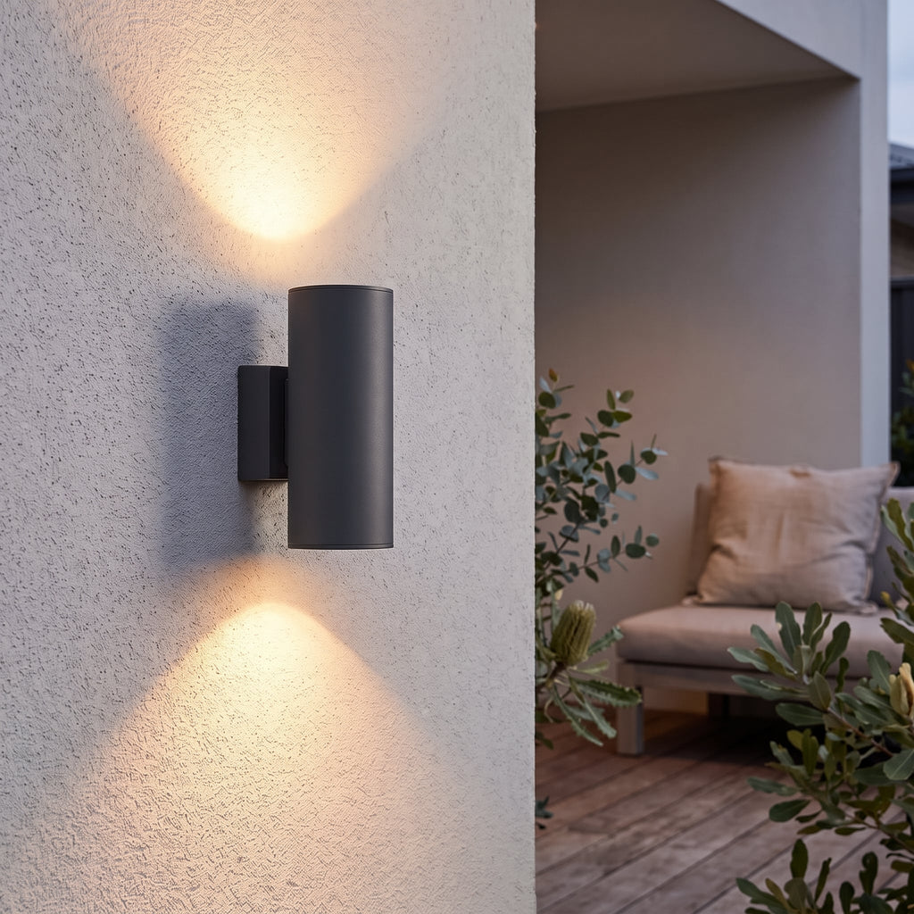 CylinderGlow wall lamp casting warm light upwards and downwards beside alfresco seating